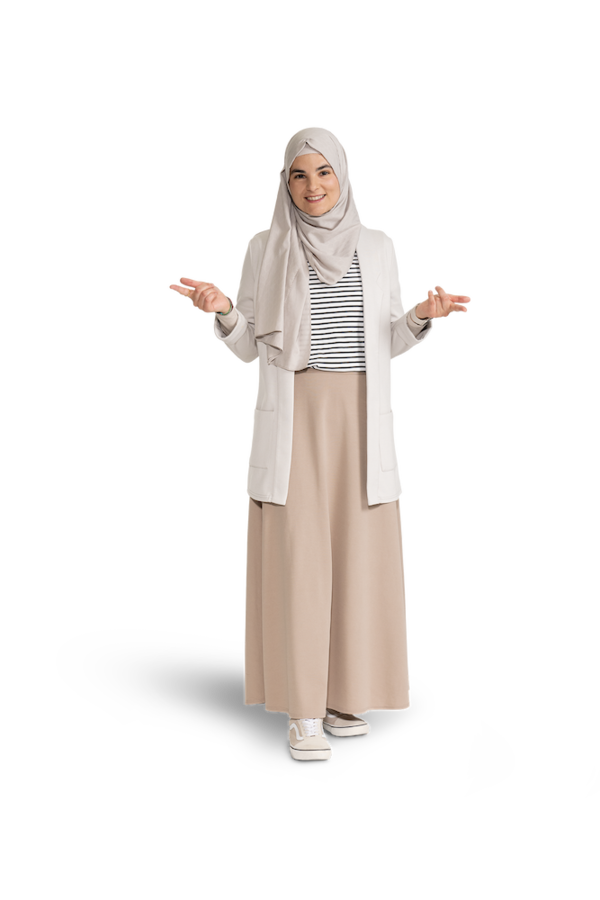 Eine junge Frau mit hellem Kopftuch,  heller Jacke, gestreiftem Shirt und heller Hose.