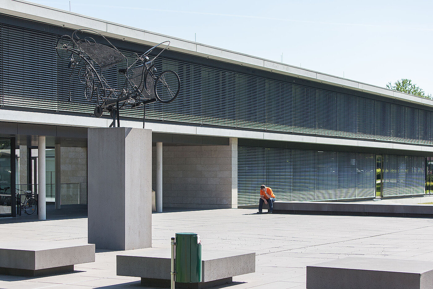 Ein modernes Gebäude mit Beton-Fassade und großem Vorplatz.  